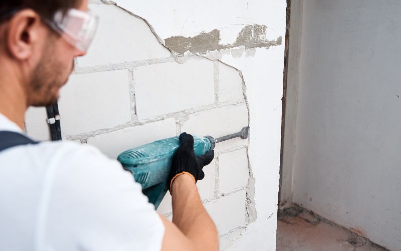 A contractor repairing stucco on a residential home, demonstrating proper maintenance techniques for stucco longevity.